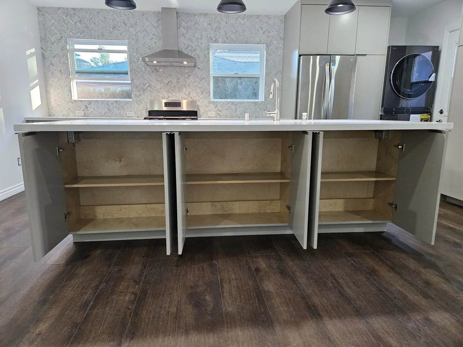 A kitchen with wooden floors and white cabinets.