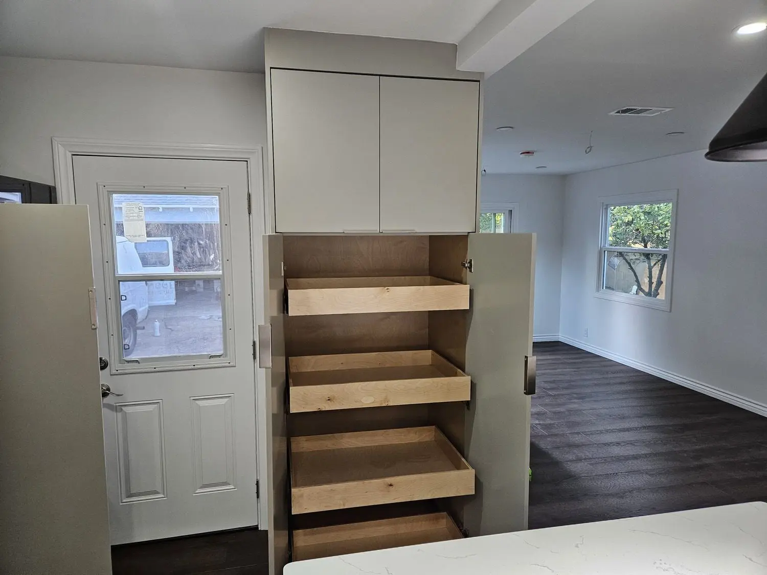 A kitchen with a pantry and shelves in it