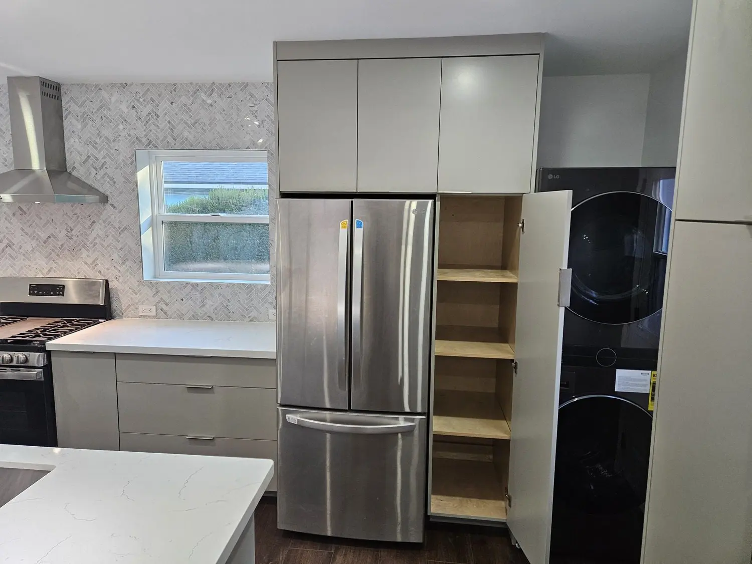 A kitchen with stainless steel refrigerator and cabinets.