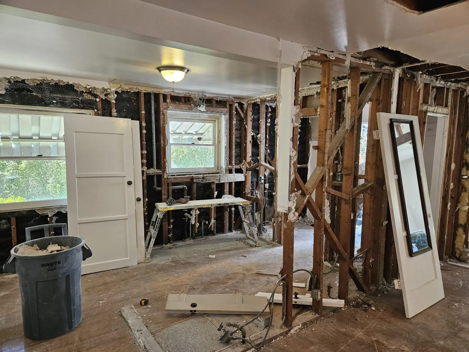 A room with many pieces of wood and some windows