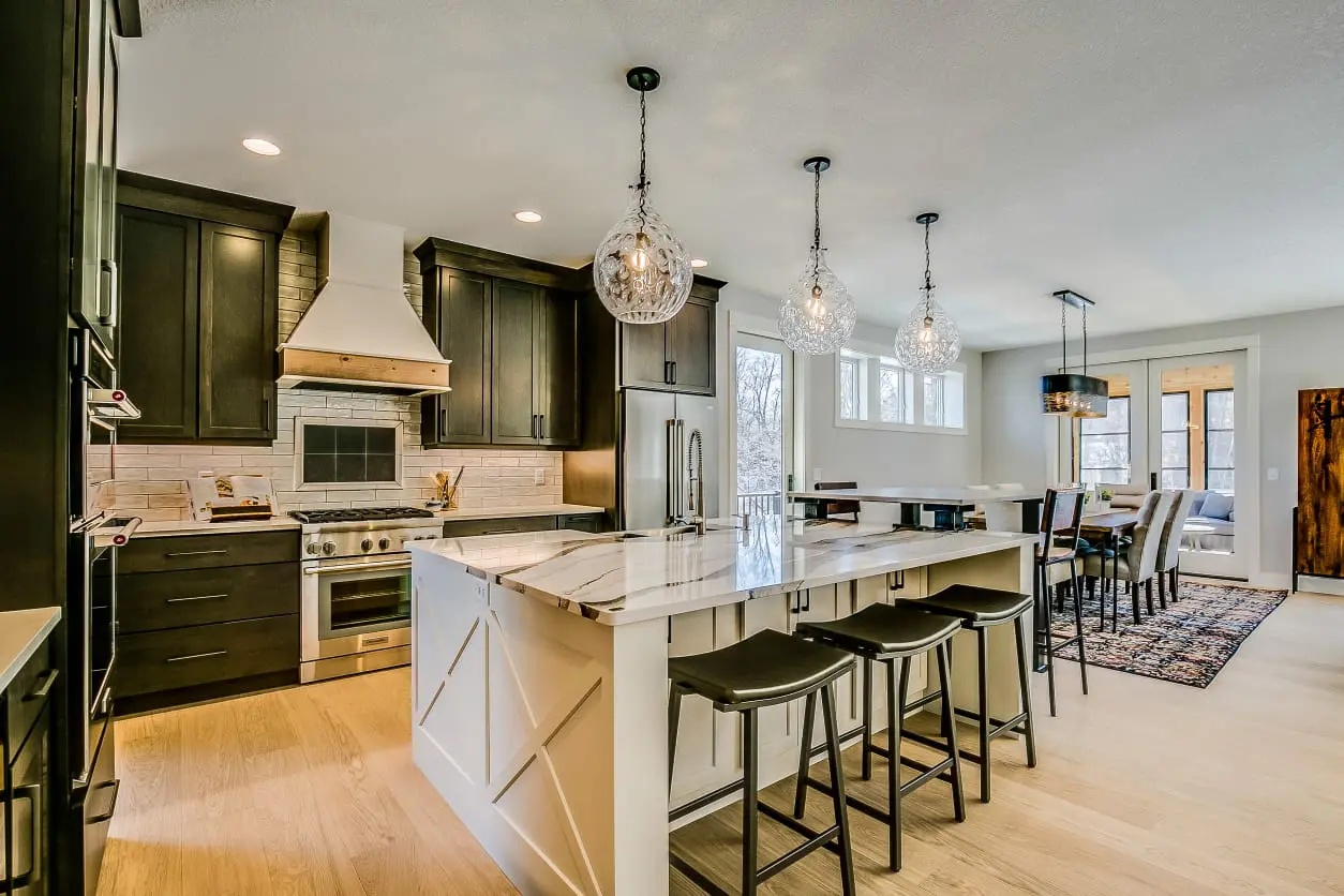 A kitchen with a large island and white cabinets.