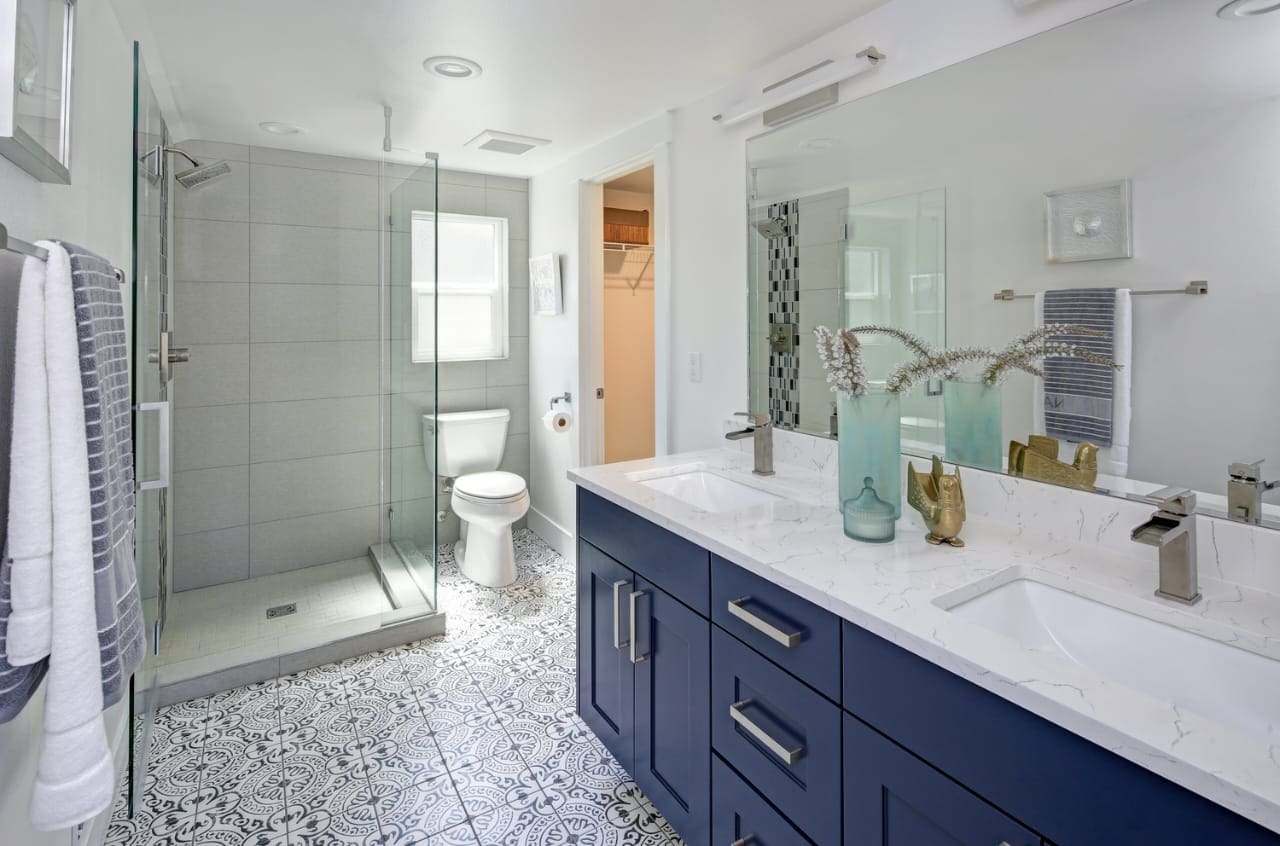 A bathroom with blue cabinets and white fixtures.