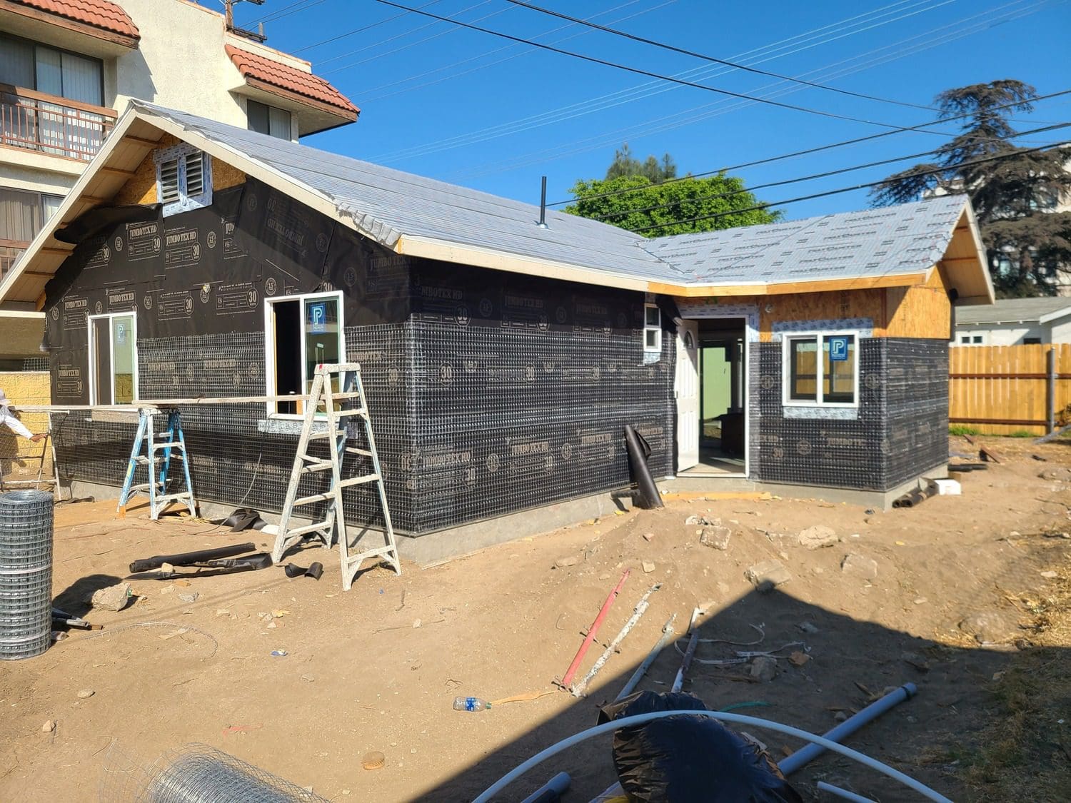 A house being built with many tools on the ground.