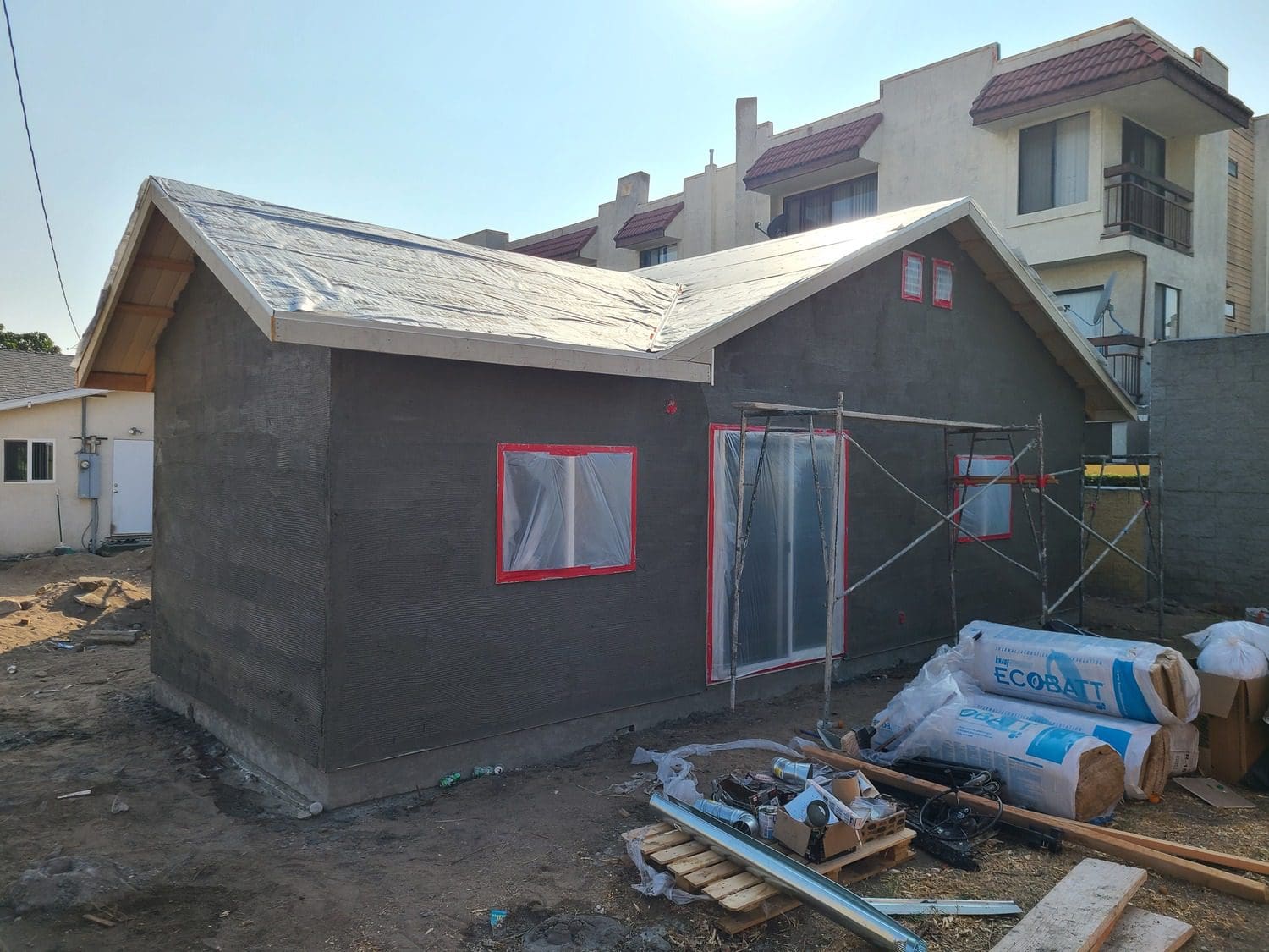 A house being built with some materials in the front yard.