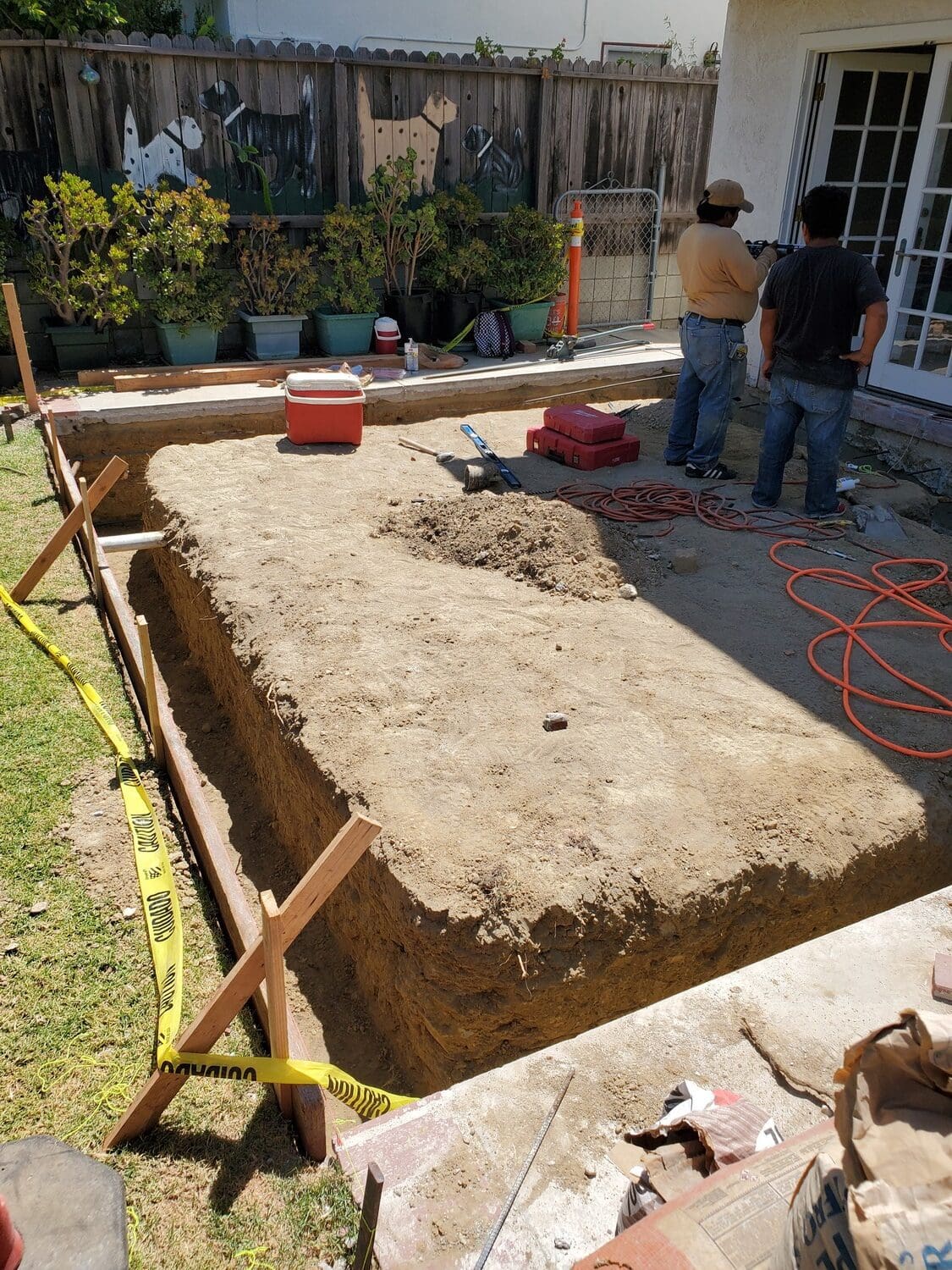 A couple of people standing next to a pile of dirt.