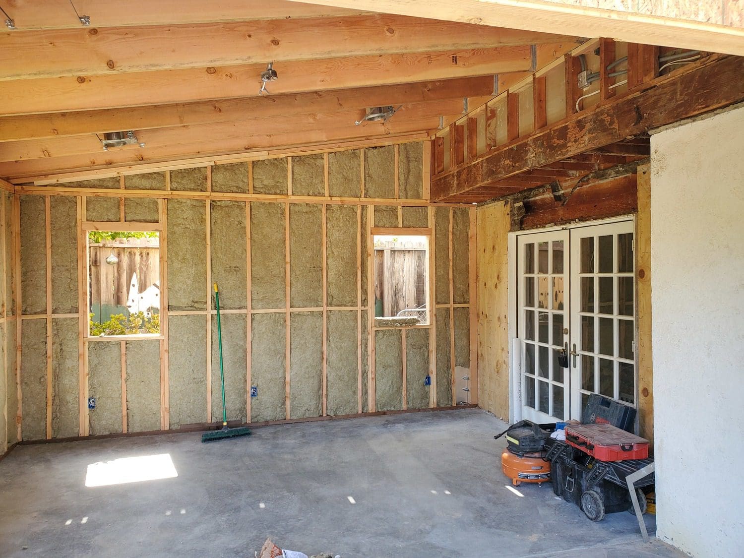 A room with walls being built and a door open.