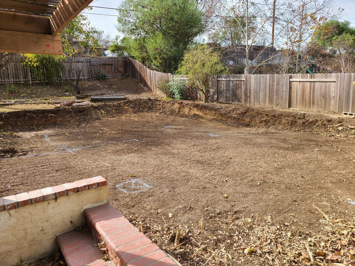 A bench in the middle of an empty yard.