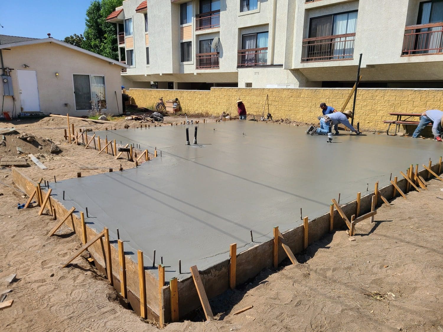 A concrete slab being poured for a house.