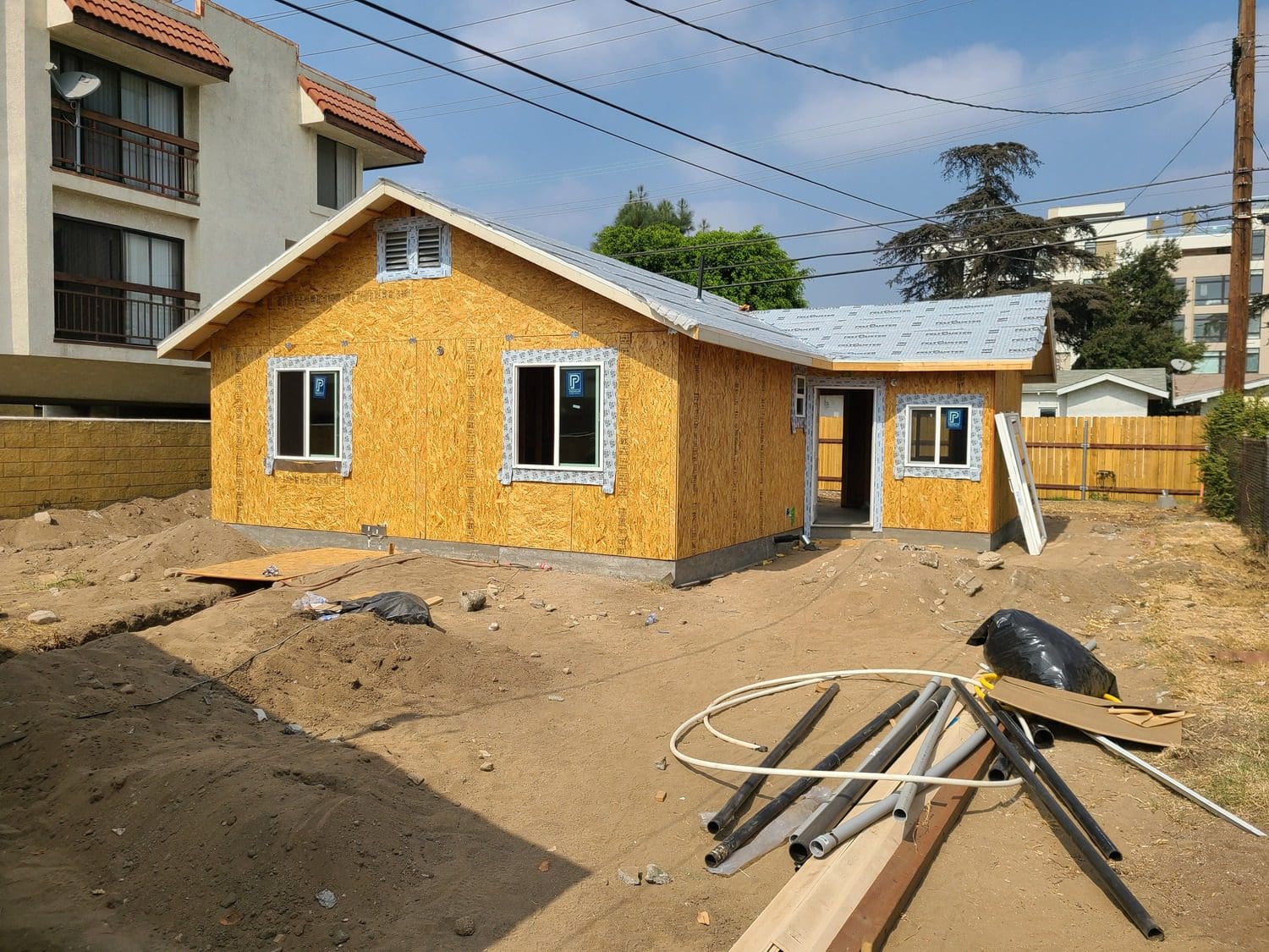 A house being built with some materials in the ground