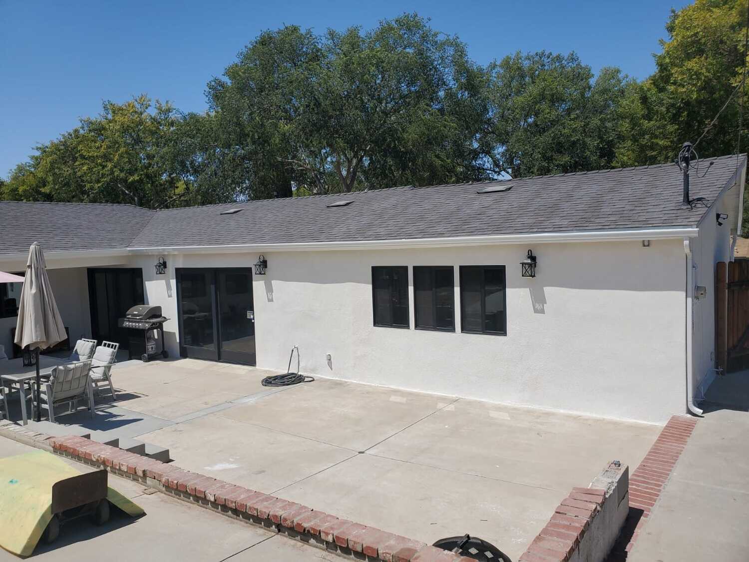 A large patio with a grill and bbq in it.